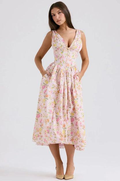 Pink - Woman wearing a white midi dress with yellow and pink floral print, featuring a corset-style bodice and a full gathered skirt.