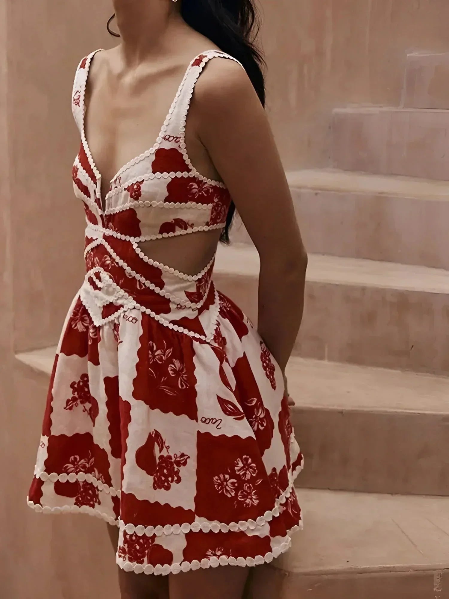 Red - Red and white bold floral mini dress featuring a plunging neckline, waist cutouts, and scalloped crochet trim.