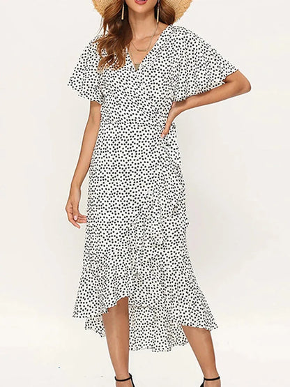 White - Woman modeling a floral print short sleeve wrap maxi dress featuring a tie waist and asymmetrical ruffled hemline.