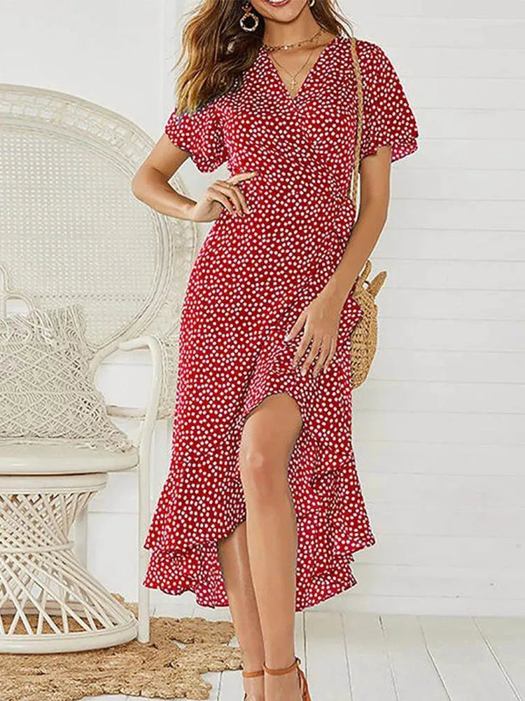 Red - Woman modeling a floral print short sleeve wrap maxi dress featuring a tie waist and asymmetrical ruffled hemline.