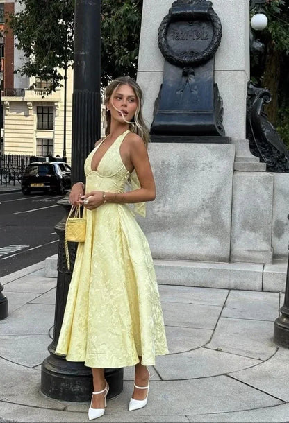 Yellow - Pale yellow floral jacquard midi dress featuring a plunging halter neckline, structured seamed bodice, and a full A-line skirt.