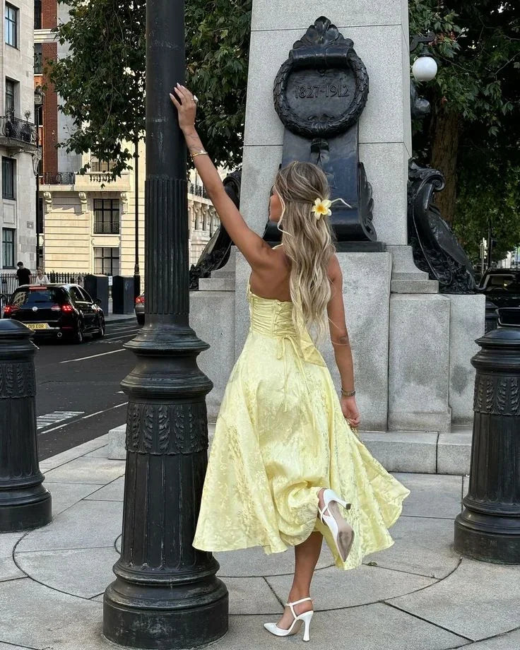 Yellow - Pale yellow floral jacquard midi dress featuring a plunging halter neckline, structured seamed bodice, and a full A-line skirt.