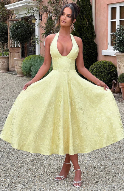 Yellow - Pale yellow floral jacquard midi dress featuring a plunging halter neckline, structured seamed bodice, and a full A-line skirt.