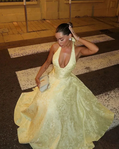 Yellow - Pale yellow floral jacquard midi dress featuring a plunging halter neckline, structured seamed bodice, and a full A-line skirt.