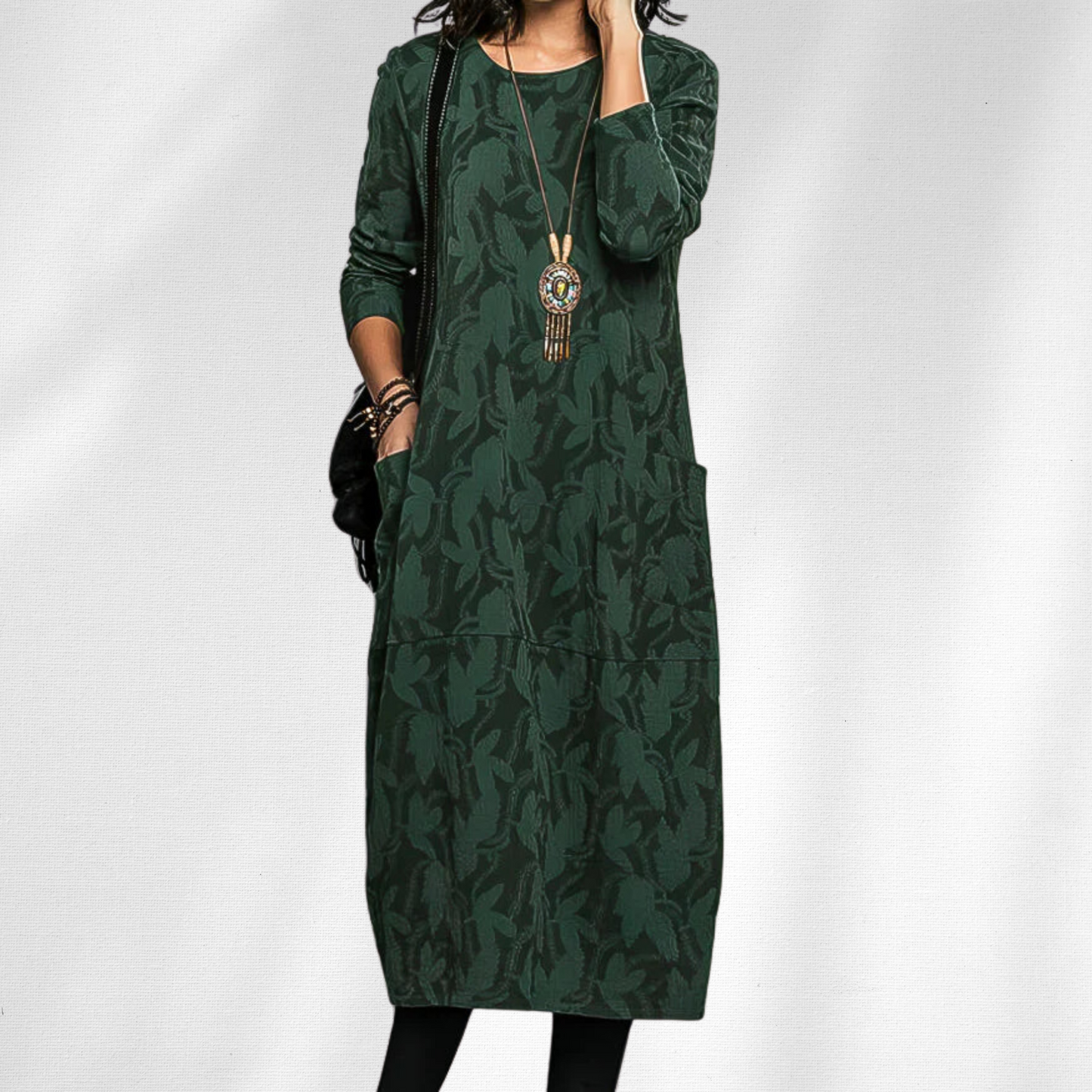 Green - Woman wearing a relaxed fit long sleeve midi dress with a tonal floral pattern and front patch pockets
