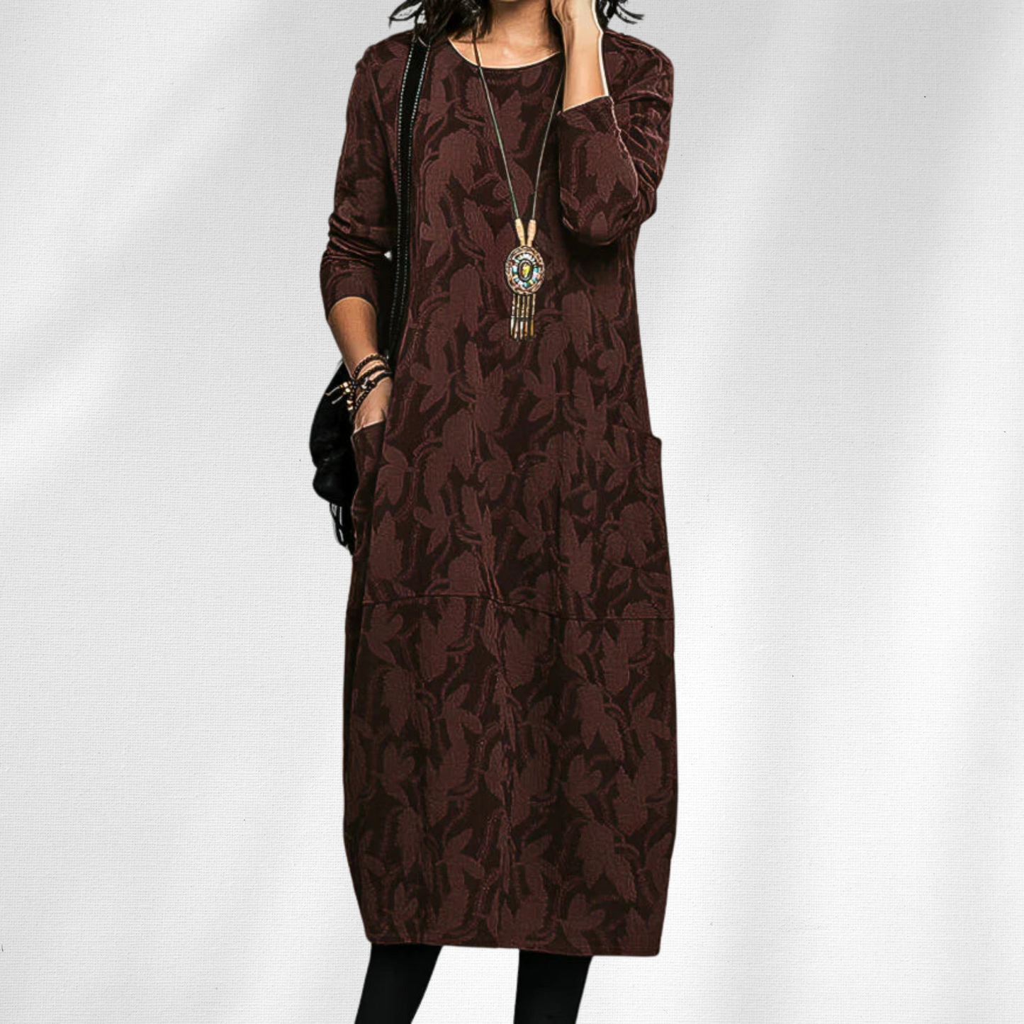 Burgundy - Woman wearing a relaxed fit long sleeve midi dress with a tonal floral pattern and front patch pockets