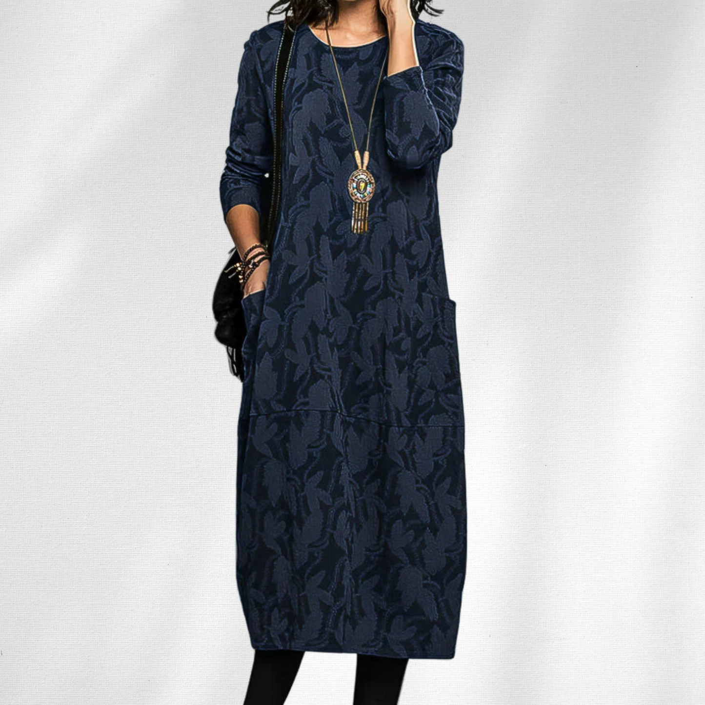 Blue - Woman wearing a relaxed fit long sleeve midi dress with a tonal floral pattern and front patch pockets