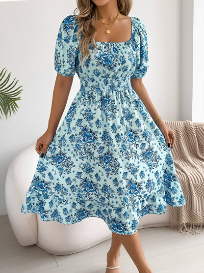Blue - Woman wearing a floral off-shoulder midi dress with puff sleeves, a smocked waist, and a ruffle hem, holding a woven straw bag