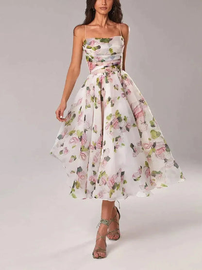 White midi dress with pink and green floral print, featuring a ruched bodice, spaghetti straps, and a full A-line skirt.