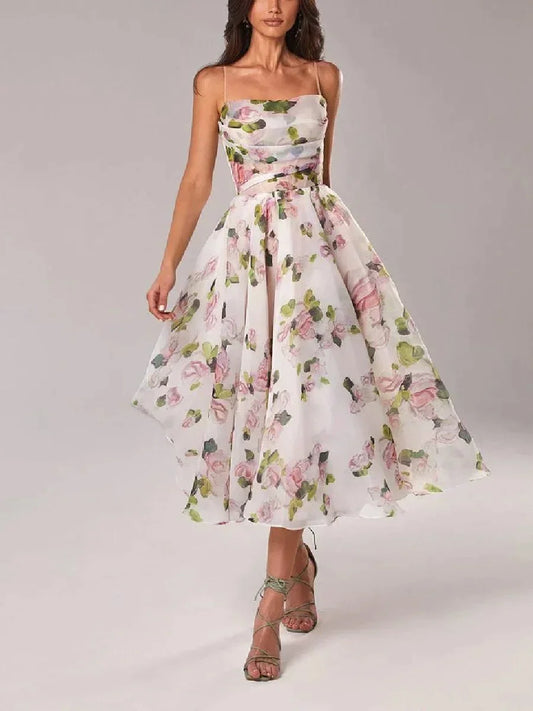 White midi dress with pink and green floral print, featuring a ruched bodice, spaghetti straps, and a full A-line skirt.