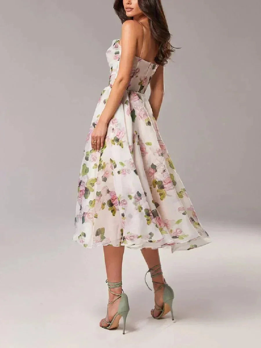 Pink - White midi dress with pink and green floral print, featuring a ruched bodice, spaghetti straps, and a full A-line skirt.