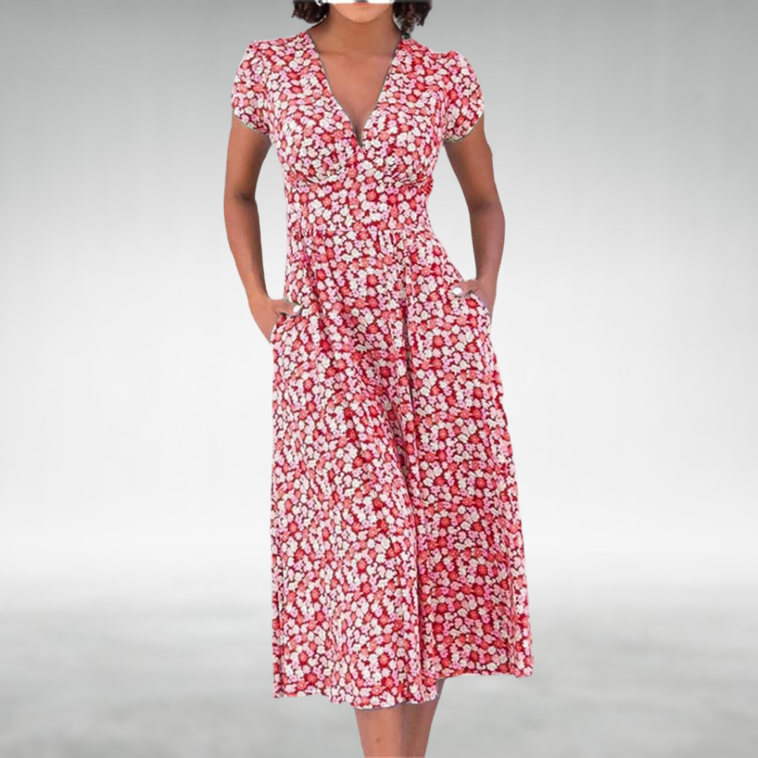 Red - A woman wearing a blue and white ditsy floral print midi dress featuring a V-neckline, short cap sleeves, and side pockets, set against a neutral gray background.