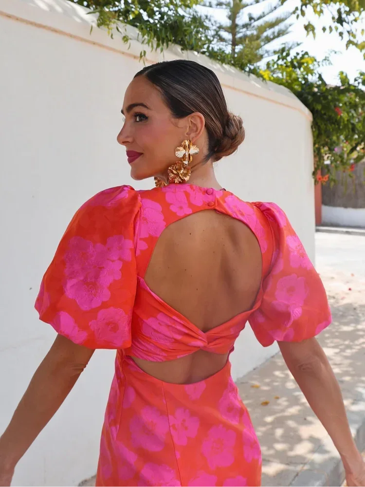 pink - Woman wearing a bright orange and pink floral mini dress with voluminous puff sleeves and a sweetheart neckline.
