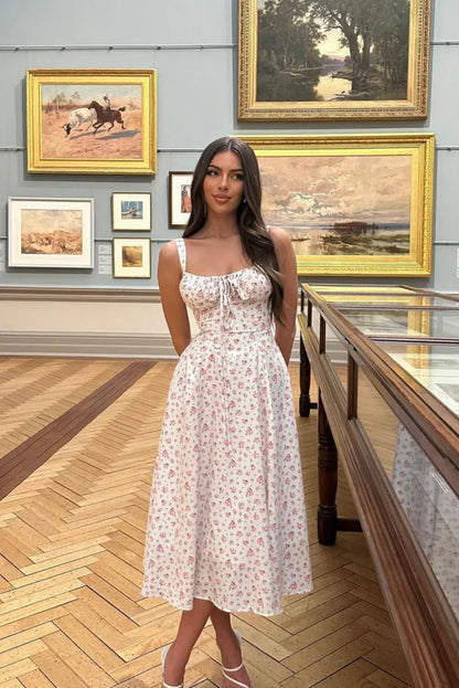 White - White midi dress with a pink floral print, featuring a ruched tie-front bust, wide shoulder straps, and a flowing A-line skirt.