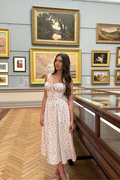 White - White midi dress with a pink floral print, featuring a ruched tie-front bust, wide shoulder straps, and a flowing A-line skirt.