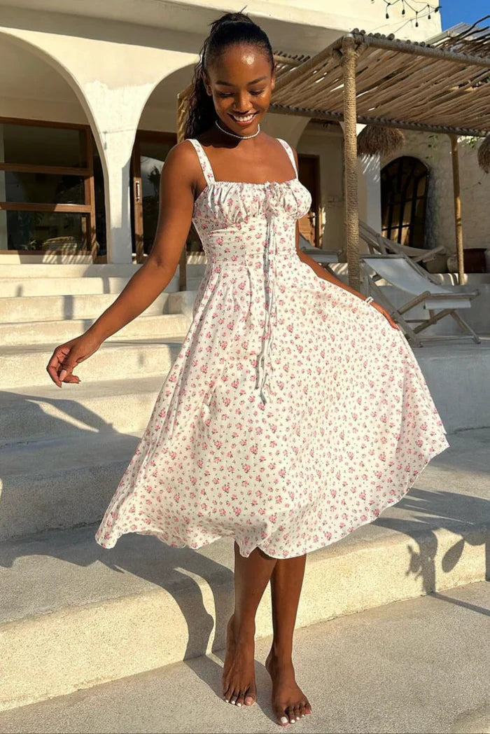 White - White midi dress with a pink floral print, featuring a ruched tie-front bust, wide shoulder straps, and a flowing A-line skirt.