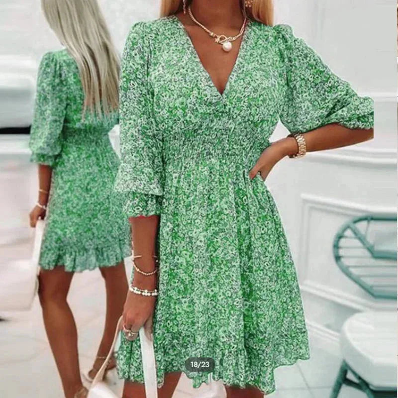 Green - Woman wearing a pink floral mini dress with a V-neckline and smocked waist.