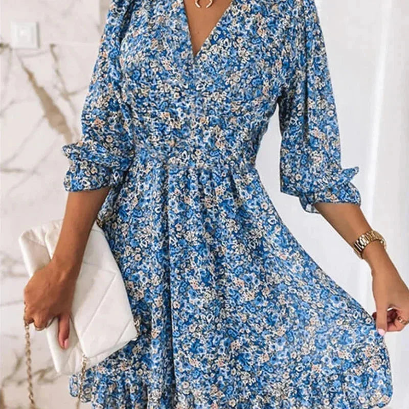 Blue - Woman wearing a pink floral mini dress with a V-neckline and smocked waist.