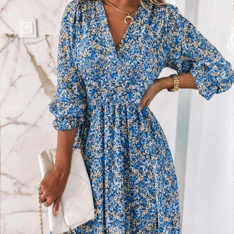 Blue - Woman wearing a pink floral mini dress with a V-neckline and smocked waist.
