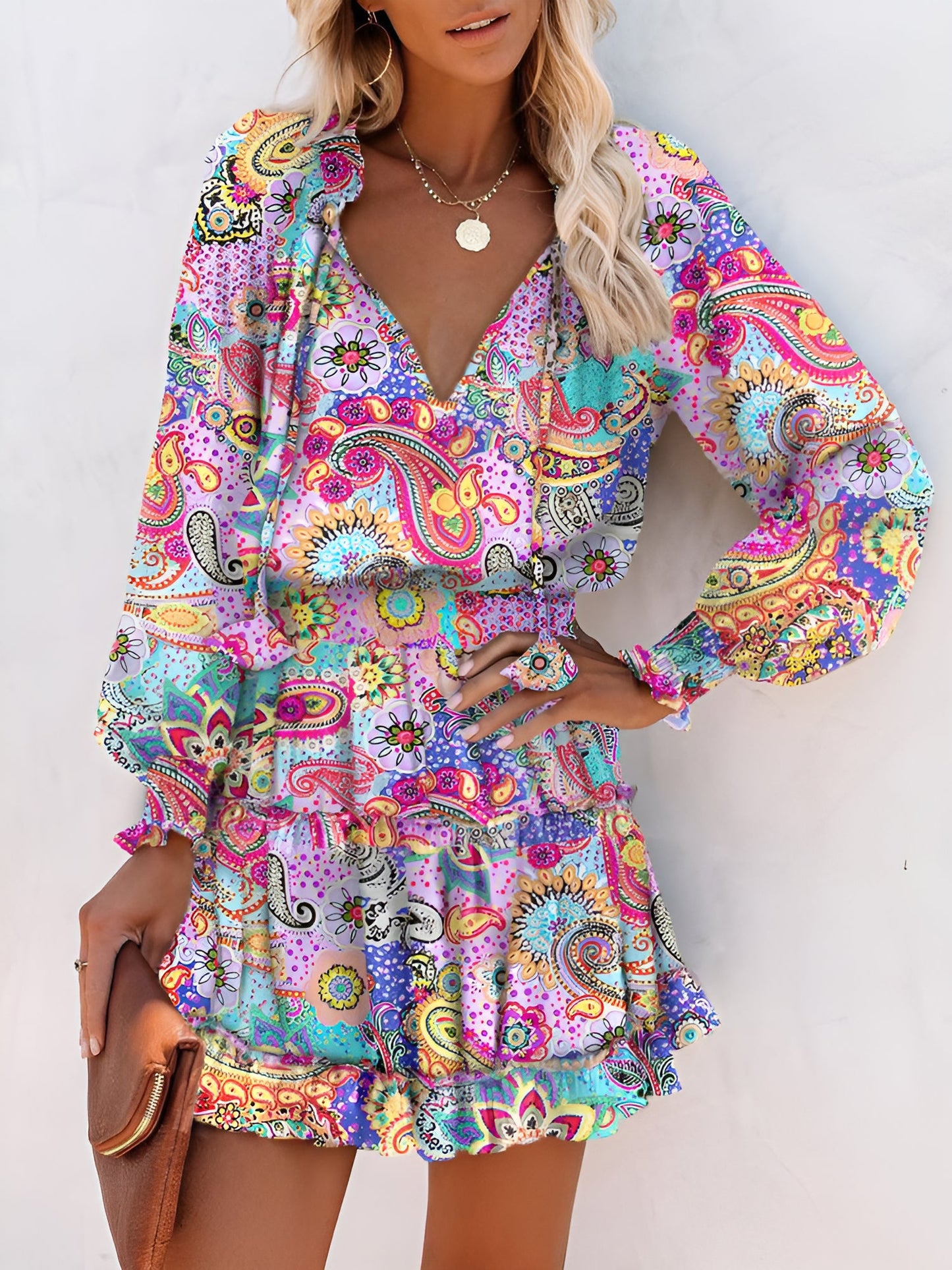 Light Purple - Woman wearing a dark mini dress with large bright floral print, featuring long sleeves, a smocked waist, and a tiered ruffle skirt