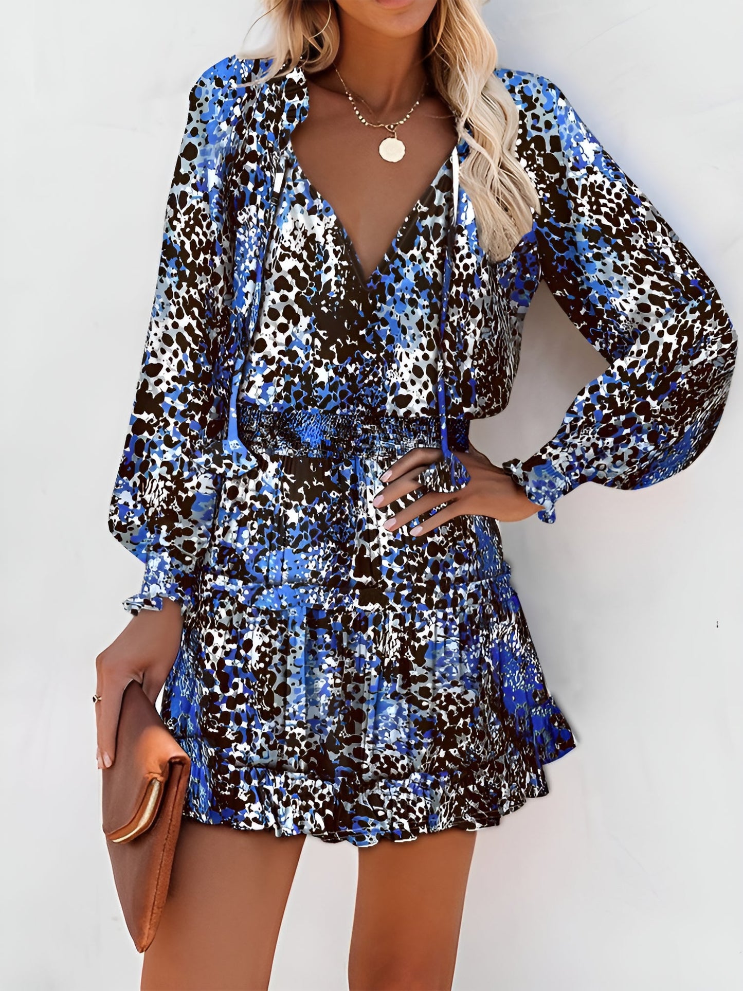 Blue - Woman wearing a dark mini dress with large bright floral print, featuring long sleeves, a smocked waist, and a tiered ruffle skirt