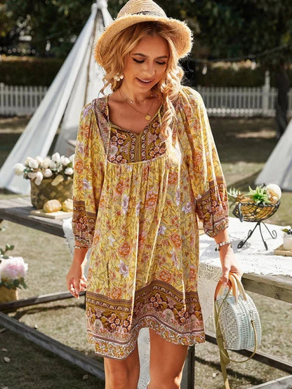Yellow - Pink bohemian floral print mini dress featuring a v-neckline with tie details, three-quarter blouson sleeves, and a relaxed shift silhouette with border print hem.
