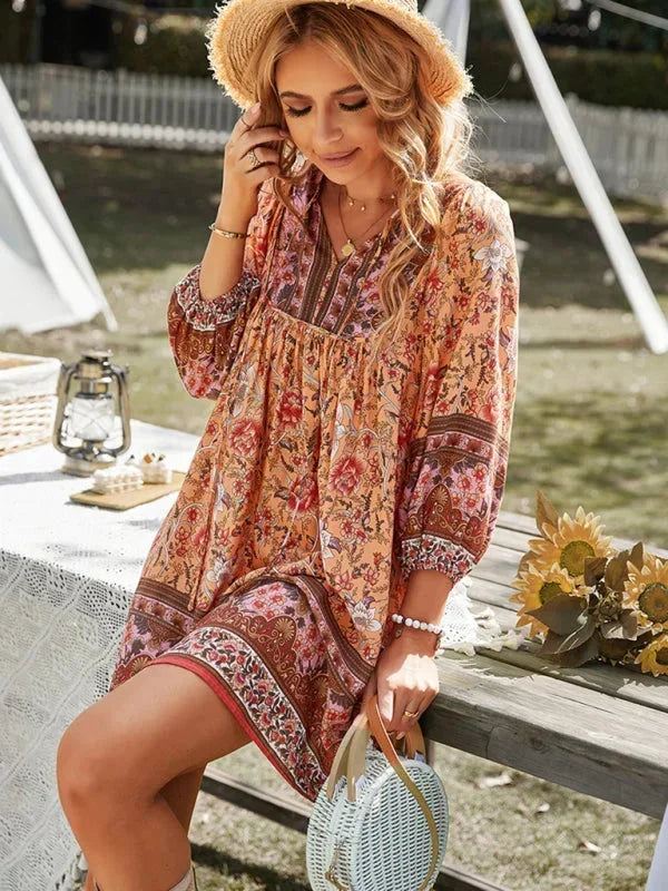 Dark blue - Pink bohemian floral print mini dress featuring a v-neckline with tie details, three-quarter blouson sleeves, and a relaxed shift silhouette with border print hem.