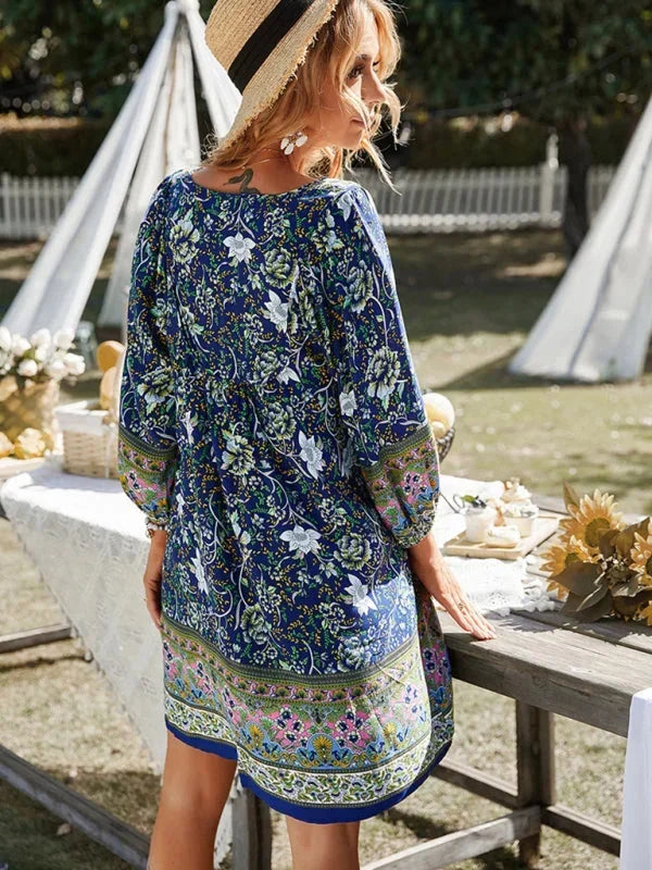 Dark blue - Pink bohemian floral print mini dress featuring a v-neckline with tie details, three-quarter blouson sleeves, and a relaxed shift silhouette with border print hem.