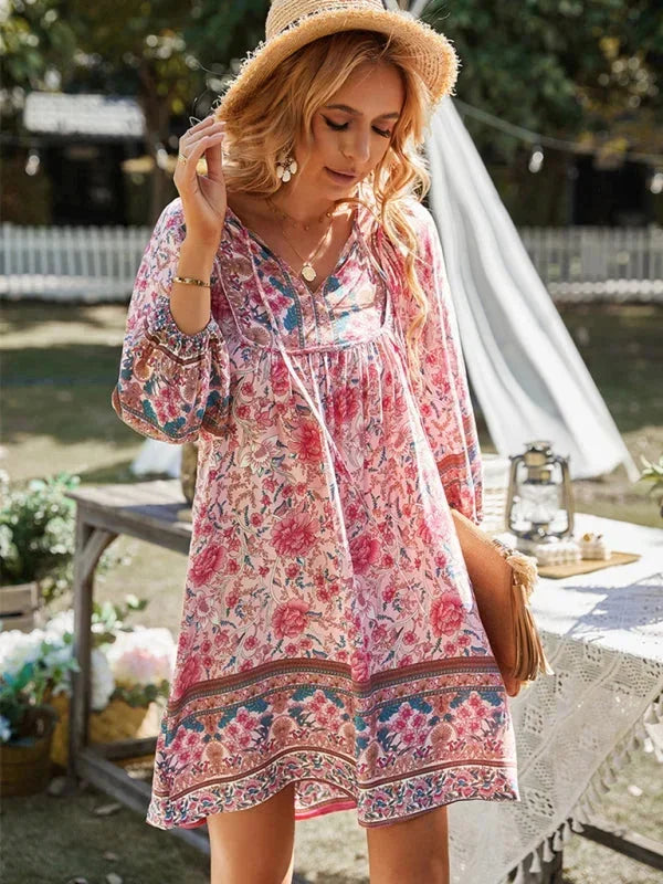 Pink - Pink bohemian floral print mini dress featuring a v-neckline with tie details, three-quarter blouson sleeves, and a relaxed shift silhouette with border print hem.