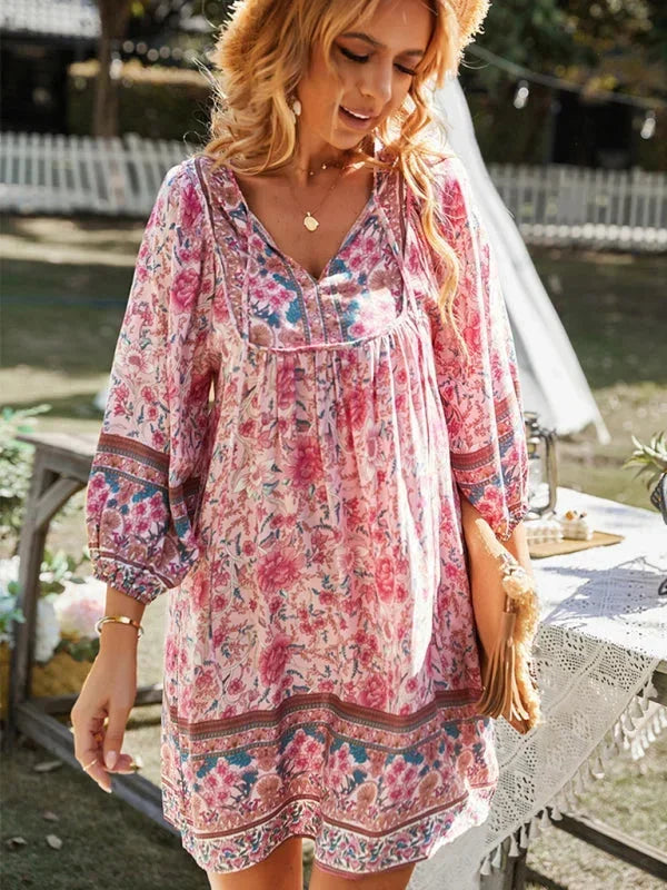 Pink - Pink bohemian floral print mini dress featuring a v-neckline with tie details, three-quarter blouson sleeves, and a relaxed shift silhouette with border print hem.
