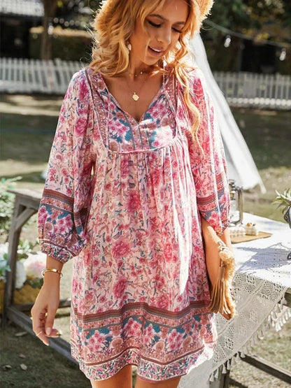 Pink - Pink bohemian floral print mini dress featuring a v-neckline with tie details, three-quarter blouson sleeves, and a relaxed shift silhouette with border print hem.