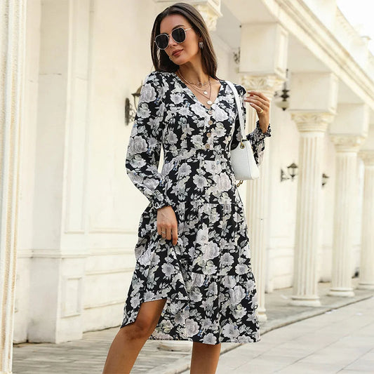 Black - Woman wearing a monochrome large-scale floral print midi dress featuring a V-neckline, button-front bodice, long sleeves, and a tiered skirt.