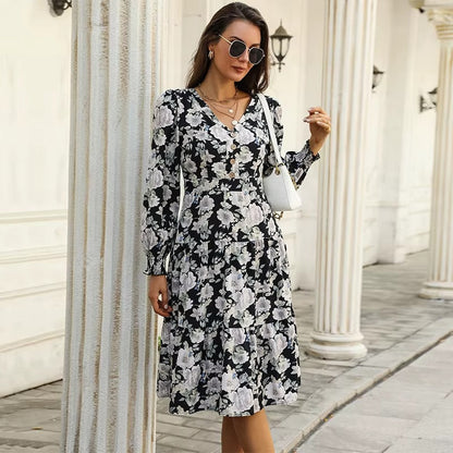 Black - Woman wearing a monochrome large-scale floral print midi dress featuring a V-neckline, button-front bodice, long sleeves, and a tiered skirt.