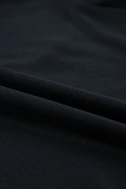 Black - Black textured mini dress featuring flutter sleeves, a high neckline, and a drop-waist ruffled hem.