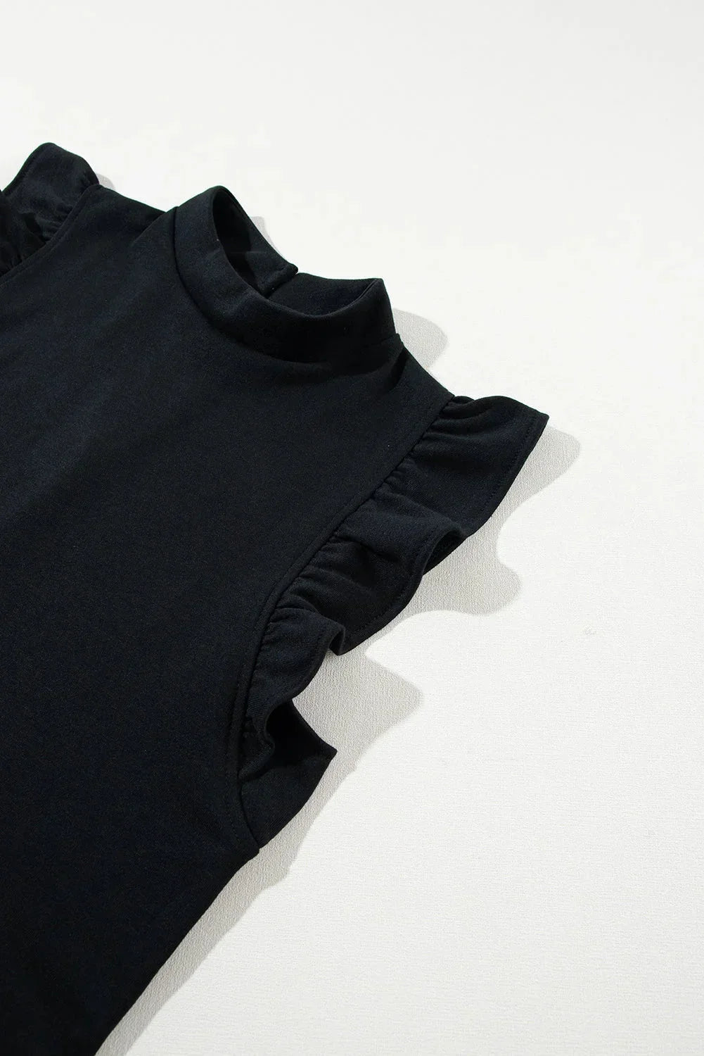 Black - Black textured mini dress featuring flutter sleeves, a high neckline, and a drop-waist ruffled hem.
