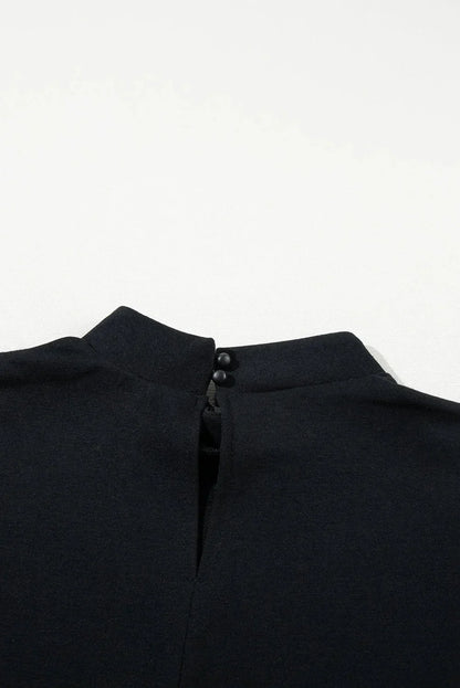 Black - Black textured mini dress featuring flutter sleeves, a high neckline, and a drop-waist ruffled hem.