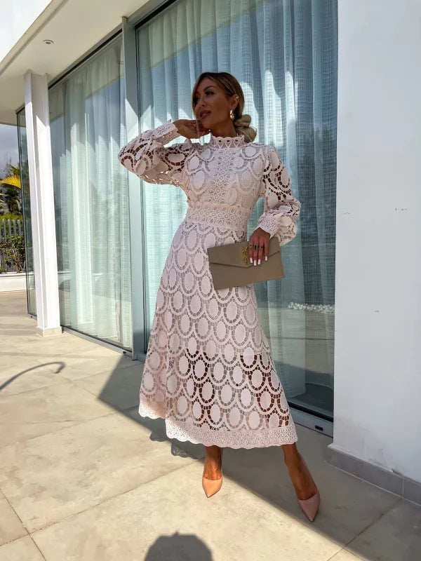 Apricot - Light blush pink geometric crochet midi dress featuring a high scalloped mock neck, long balloon sleeves, banded waist, and partially lined A-line skirt.