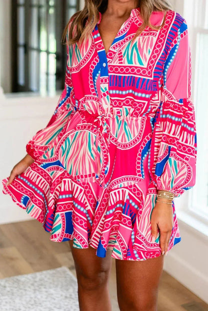 Pink - Bright pink and blue geometric scarf print mini dress featuring a collared v-neckline, long balloon sleeves, a drawstring waist, and a ruffled flounce hem.