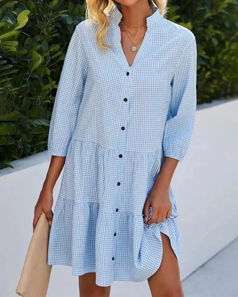 Blue - Light blue and white gingham mini dress featuring a split v-neckline, contrasting button-front closure, three-quarter sleeves, and a voluminous tiered skirt.