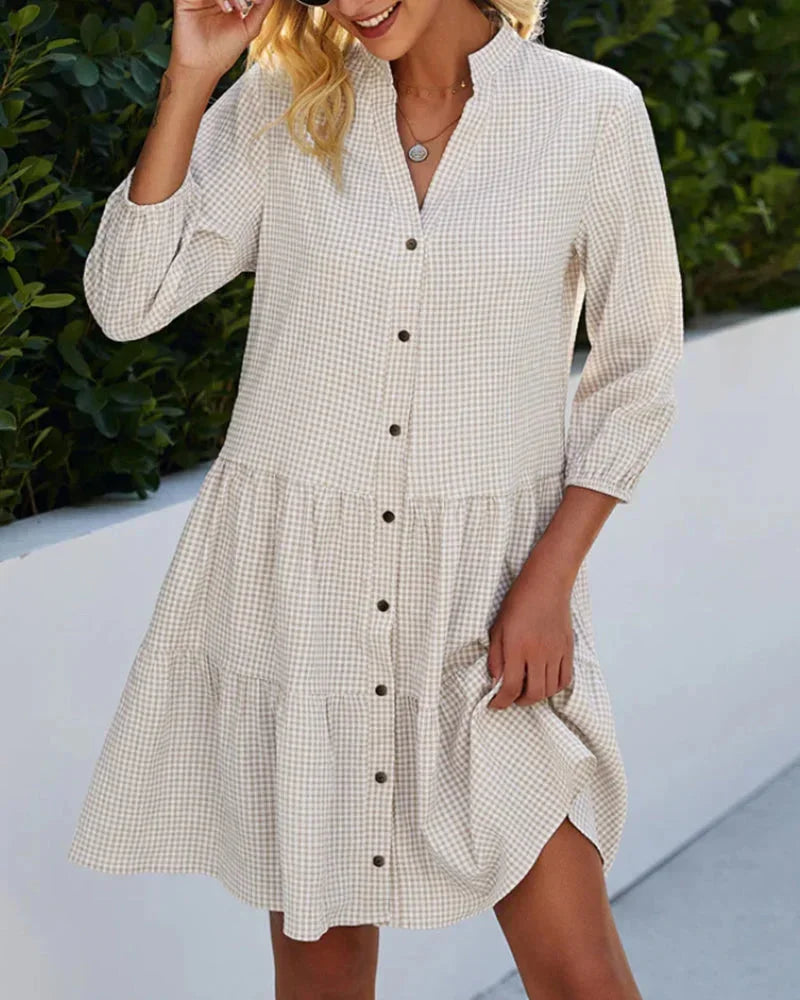 Khaki - Light blue and white gingham mini dress featuring a split v-neckline, contrasting button-front closure, three-quarter sleeves, and a voluminous tiered skirt.