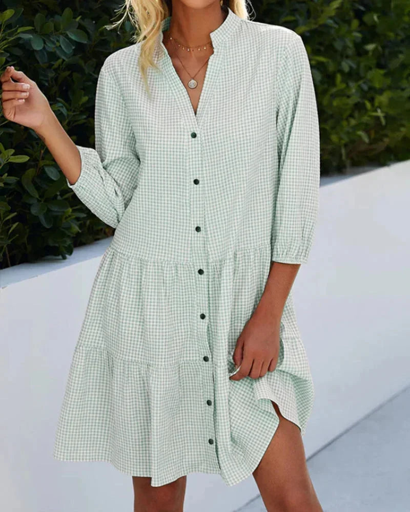 Green - Light blue and white gingham mini dress featuring a split v-neckline, contrasting button-front closure, three-quarter sleeves, and a voluminous tiered skirt.