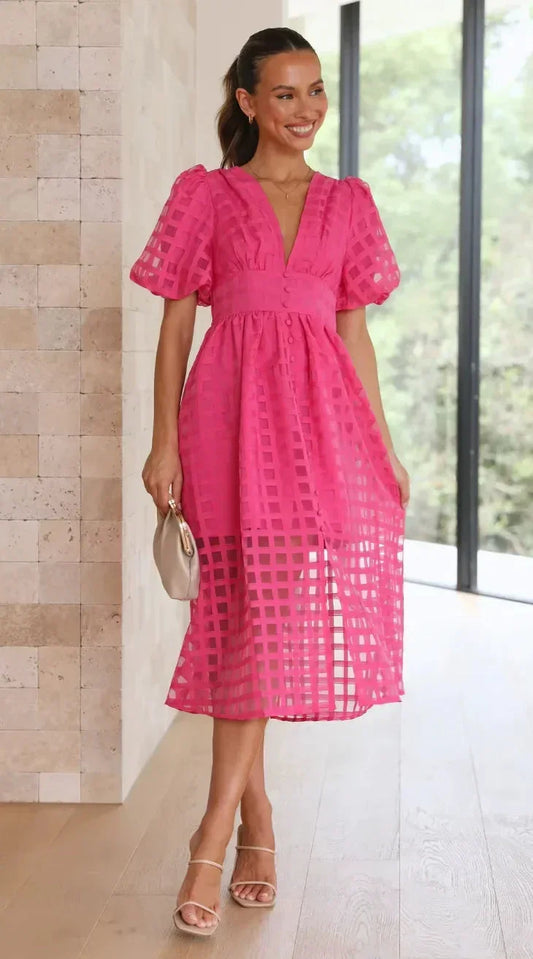 Bright pink A-line midi dress featuring a sheer grid jacquard overlay, short puff sleeves, plunging V-neckline, and a button-front bodice.
