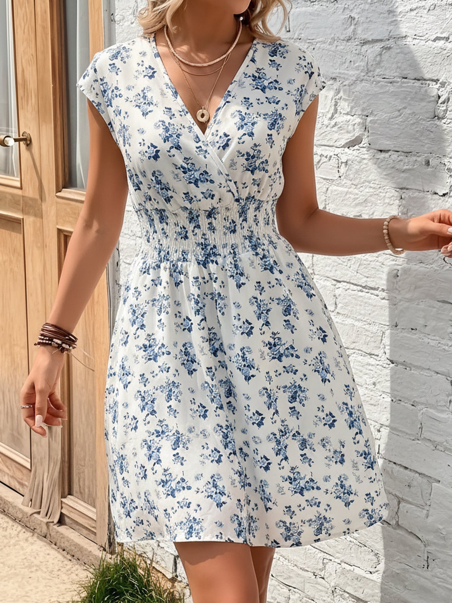 Blue - Woman wearing a lightweight chiffon mini dress with a leopard print, cap sleeves, and a smocked waist