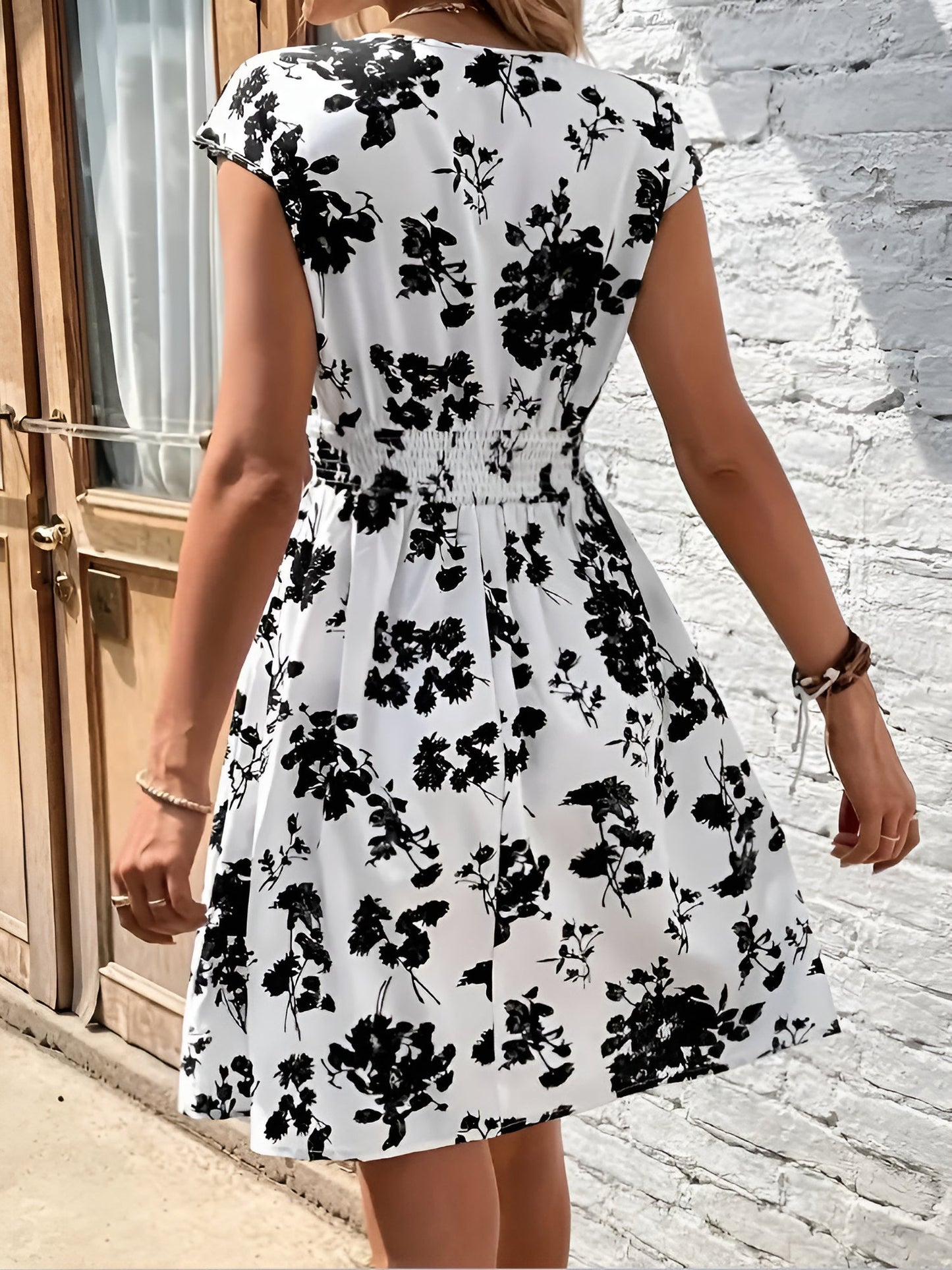 White - Woman wearing a lightweight chiffon mini dress with a leopard print, cap sleeves, and a smocked waist