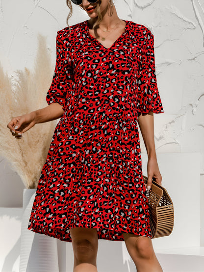 Red - Woman wearing a lightweight leopard print mini dress with flutter sleeves, a tie neckline, and a tiered skirt.