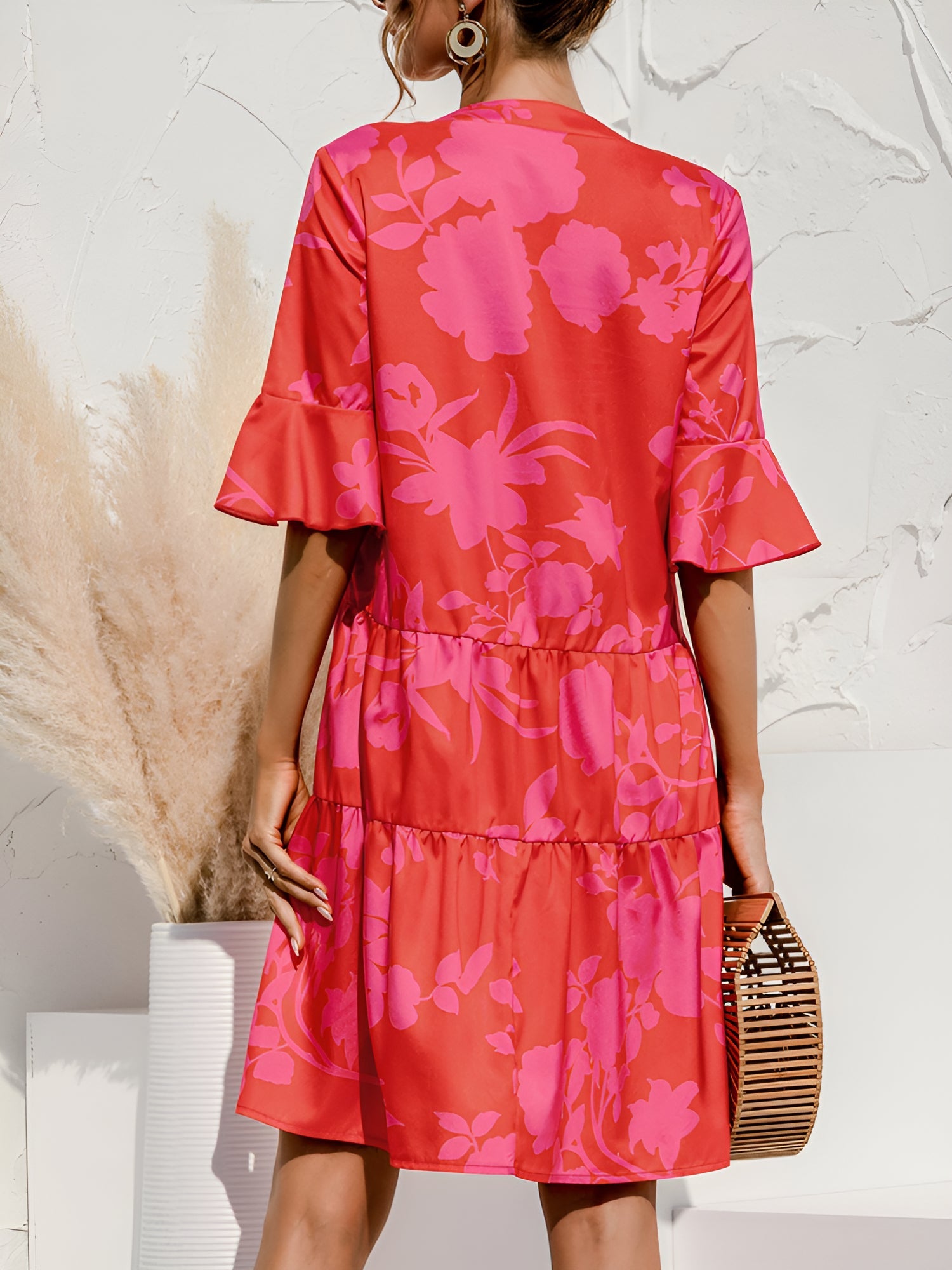 Rose Red - Woman wearing a lightweight leopard print mini dress with flutter sleeves, a tie neckline, and a tiered skirt.