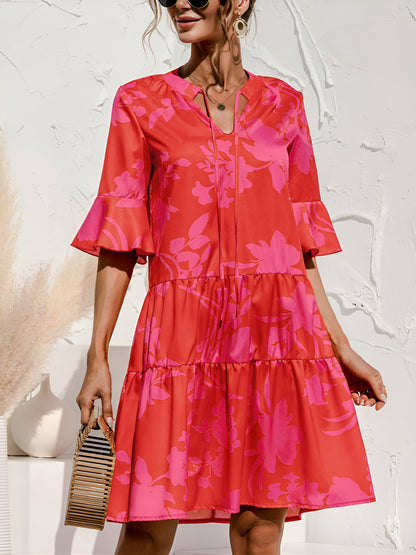 Rose Red - Woman wearing a lightweight leopard print mini dress with flutter sleeves, a tie neckline, and a tiered skirt.