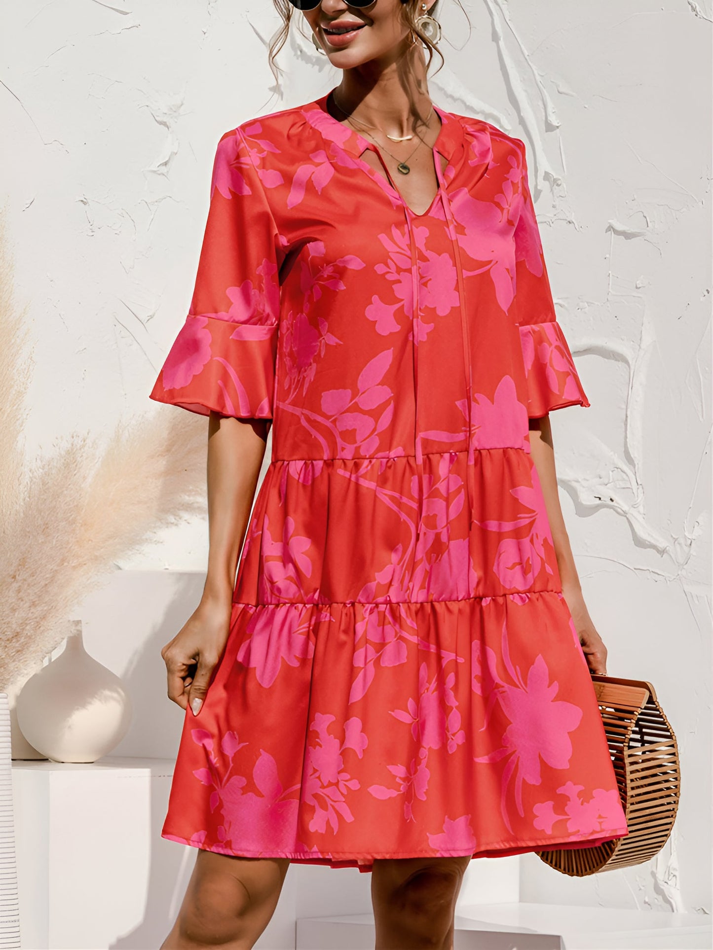 Rose Red - Woman wearing a lightweight leopard print mini dress with flutter sleeves, a tie neckline, and a tiered skirt.