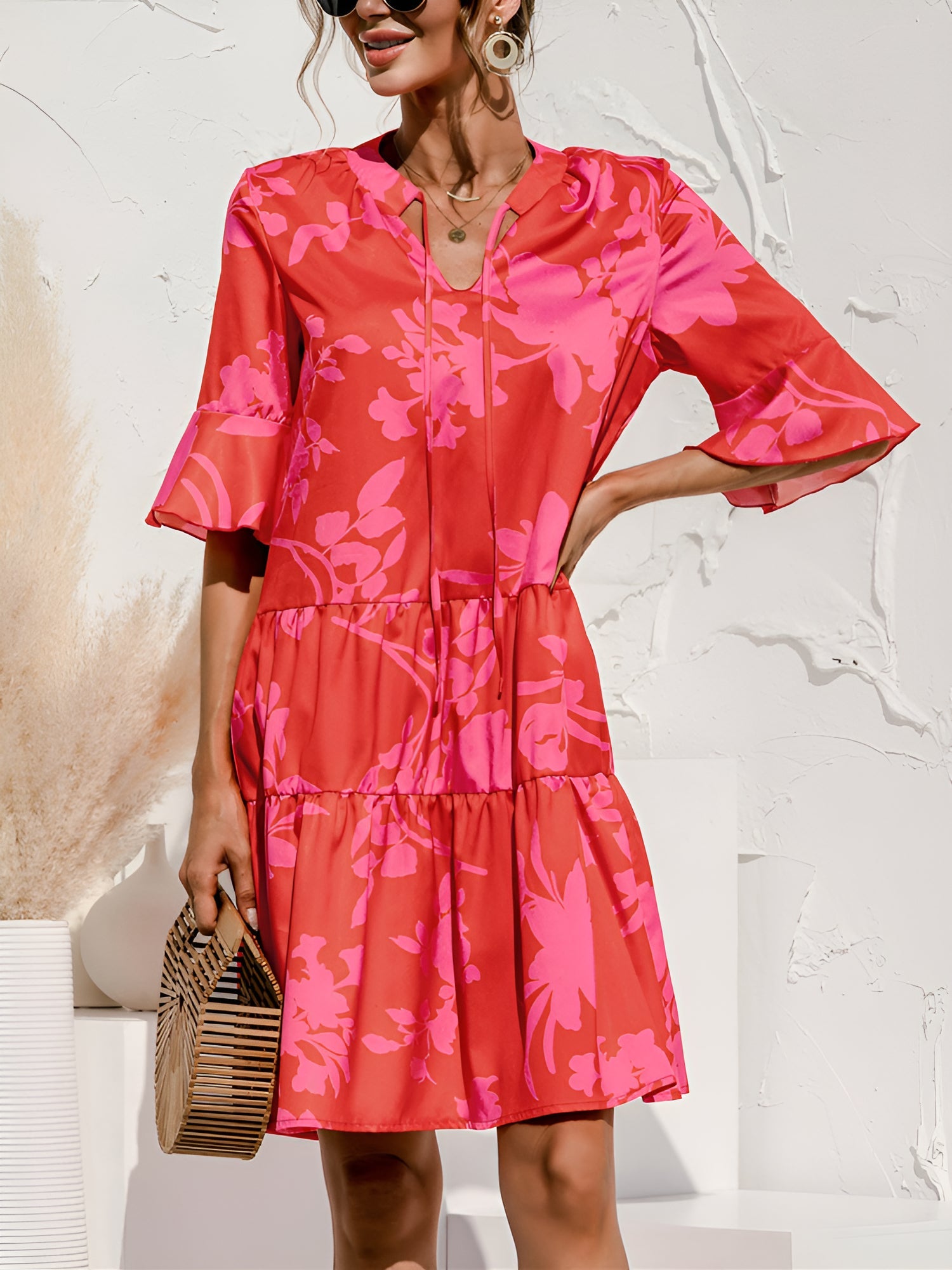 Rose Red - Woman wearing a lightweight leopard print mini dress with flutter sleeves, a tie neckline, and a tiered skirt.