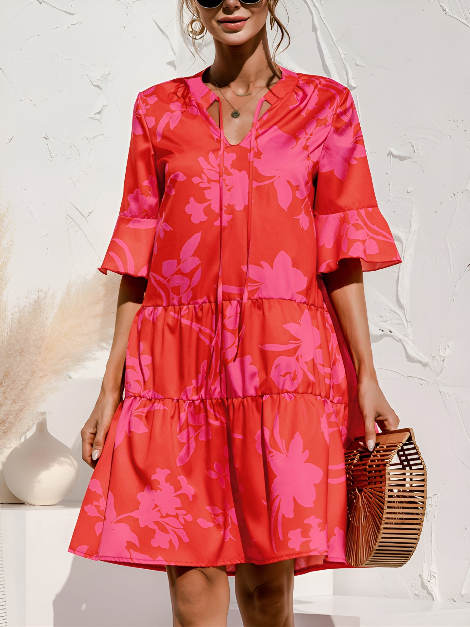 Rose Red - Woman wearing a lightweight leopard print mini dress with flutter sleeves, a tie neckline, and a tiered skirt.